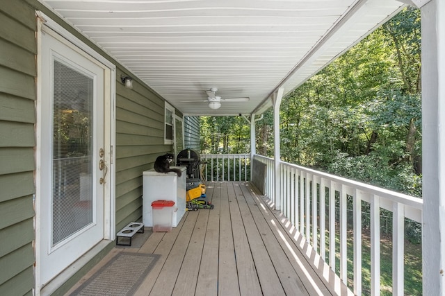 wooden deck featuring covered porch and ceiling fan