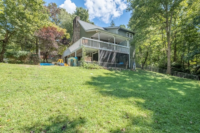 rear view of property featuring stairway, a lawn, a chimney, and fence