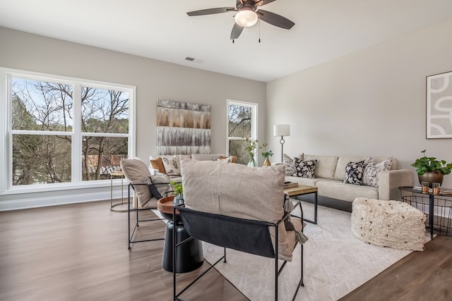 living area with a ceiling fan, wood finished floors, and visible vents