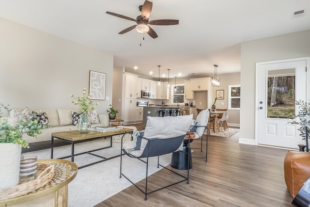 living room with visible vents, a ceiling fan, wood finished floors, recessed lighting, and baseboards