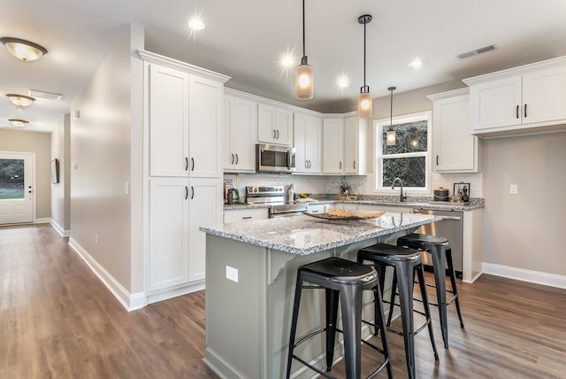 kitchen featuring stainless steel appliances, tasteful backsplash, and white cabinets