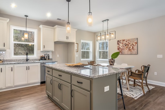 kitchen with dishwasher, dark wood-style floors, tasteful backsplash, and a kitchen island