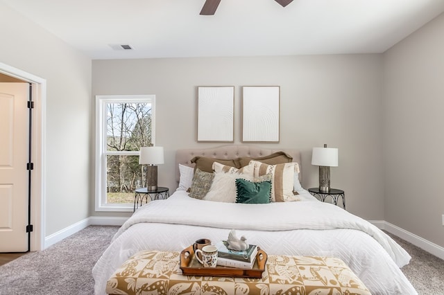 carpeted bedroom featuring baseboards, multiple windows, visible vents, and a ceiling fan