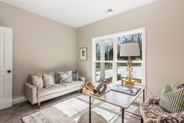 carpeted living area featuring baseboards and visible vents