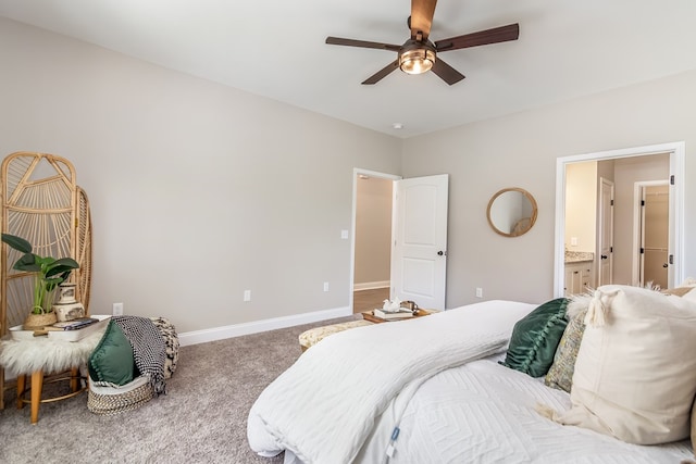 carpeted bedroom featuring baseboards, ensuite bathroom, and ceiling fan