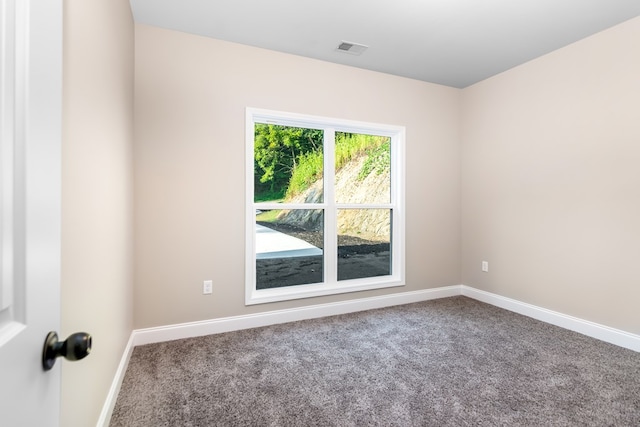 carpeted empty room featuring visible vents and baseboards