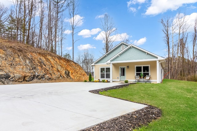 view of front of home with a front yard and covered porch