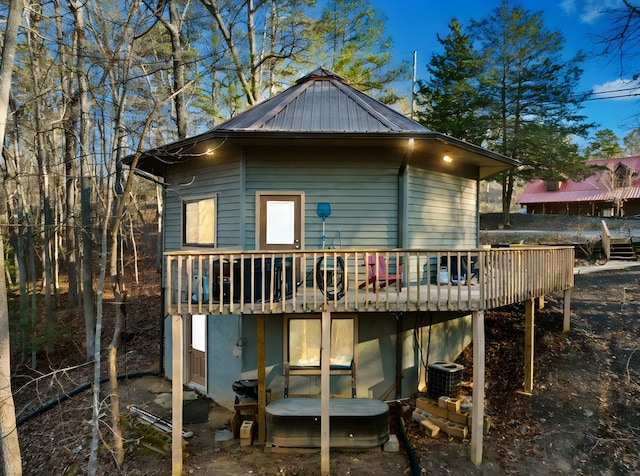 rear view of property with central AC unit and a wooden deck