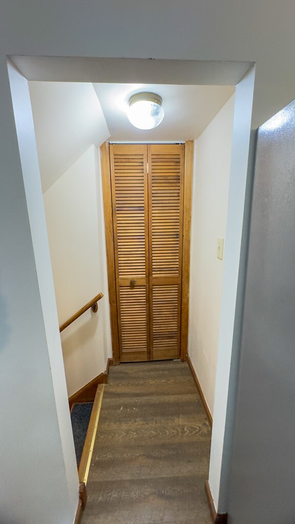 stairs featuring lofted ceiling and hardwood / wood-style floors