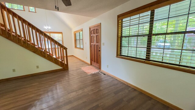 foyer entrance featuring an inviting chandelier, vaulted ceiling, and hardwood / wood-style floors