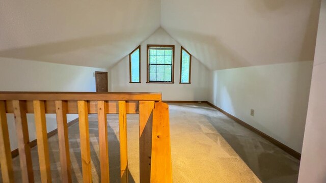 bonus room featuring vaulted ceiling and carpet flooring