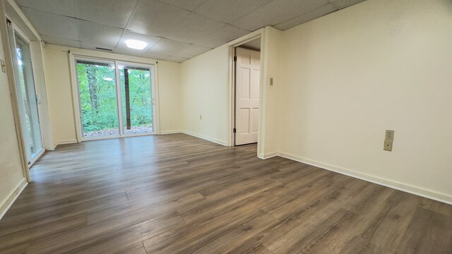 spare room featuring a drop ceiling and dark hardwood / wood-style floors