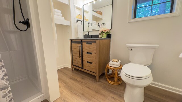 bathroom featuring a shower with curtain, vanity, hardwood / wood-style floors, and toilet