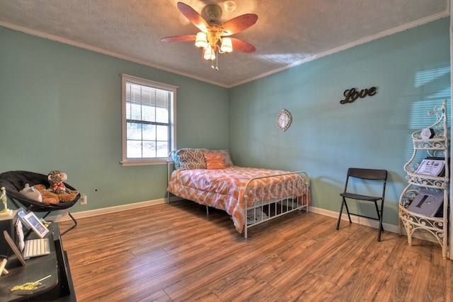 bedroom featuring hardwood / wood-style flooring, ceiling fan, ornamental molding, and a textured ceiling