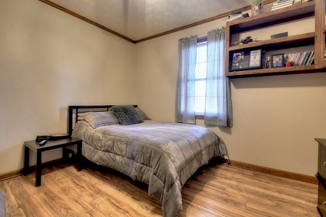 bedroom featuring ornamental molding, a textured ceiling, and light wood-type flooring