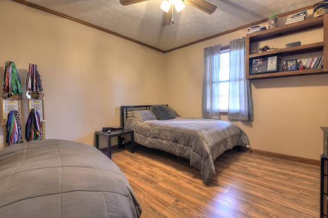 bedroom with wood-type flooring, ceiling fan, a textured ceiling, and crown molding