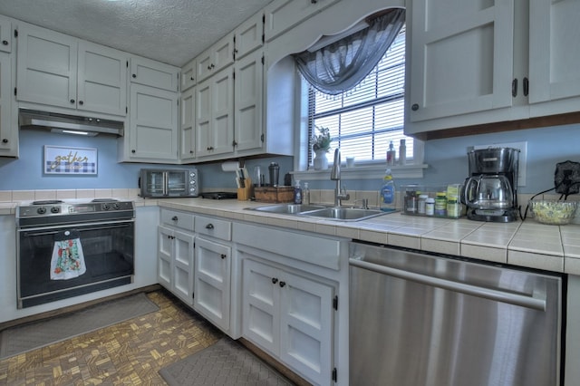 kitchen with sink, dishwasher, electric range oven, white cabinets, and tile countertops