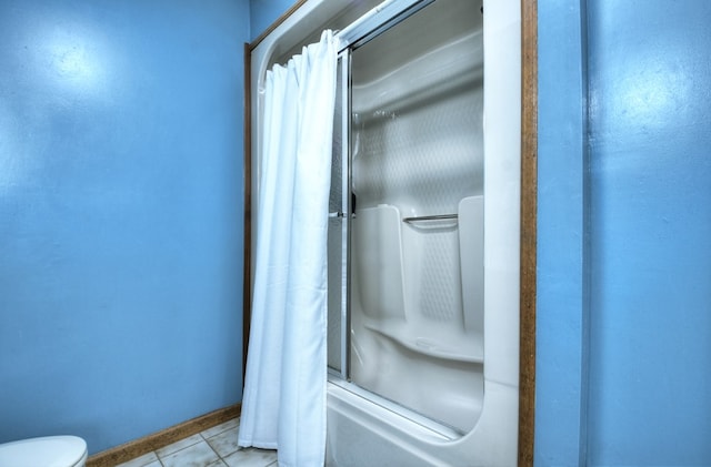 bathroom with tile patterned flooring, shower / bath combo, and toilet