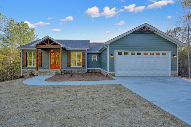 view of front of home featuring a garage, stone siding, driveway, and roof with shingles