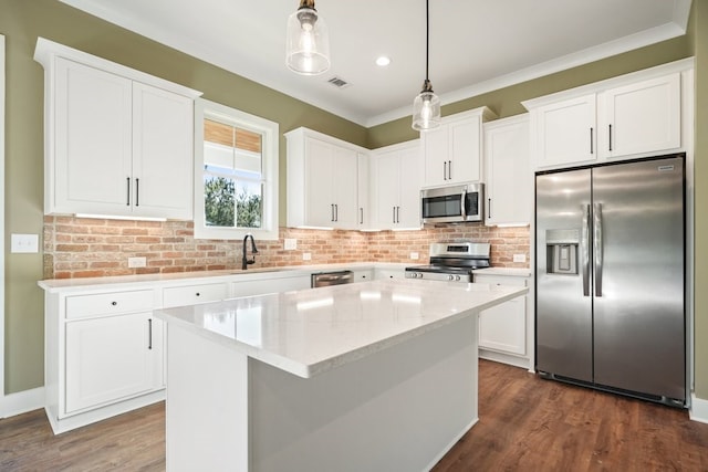 kitchen with dark wood-style floors, a center island, crown molding, stainless steel appliances, and hanging light fixtures