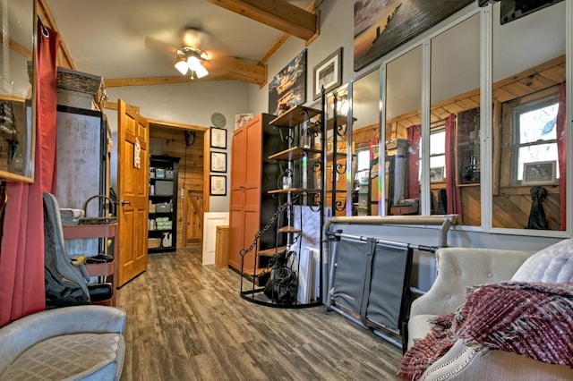 interior space featuring lofted ceiling with beams, ceiling fan, and wood-type flooring