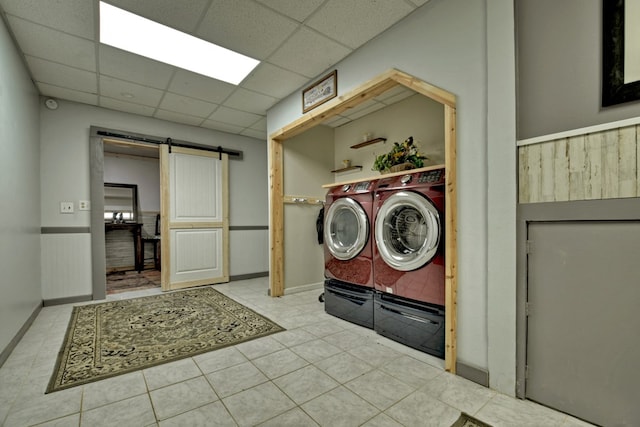 laundry area with a barn door and washing machine and clothes dryer