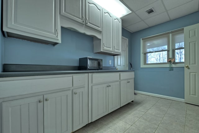 kitchen featuring white cabinetry and a drop ceiling