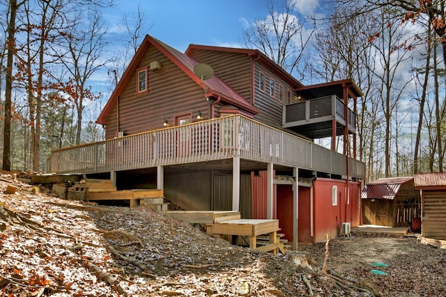 snow covered property featuring a deck and a storage shed