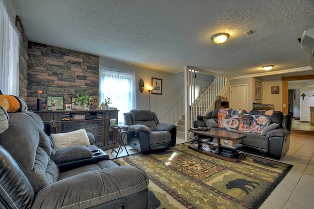 living area featuring ornamental molding, stairway, a textured ceiling, and light tile patterned floors