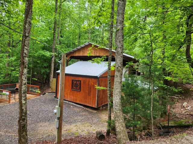 view of outdoor structure with an outbuilding and a view of trees