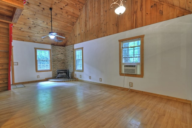 unfurnished living room with high vaulted ceiling, light wood-type flooring, healthy amount of natural light, baseboards, and wooden ceiling