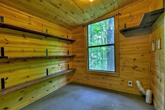 carpeted empty room featuring wooden walls, lofted ceiling, a sauna, and wood ceiling
