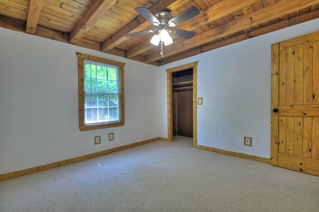 unfurnished bedroom with wooden ceiling with exposed beams, carpet floors, baseboards, and ceiling fan