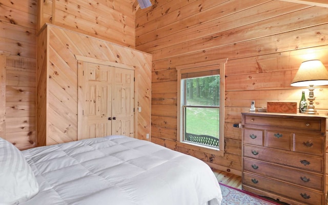 bedroom featuring a closet and wood walls