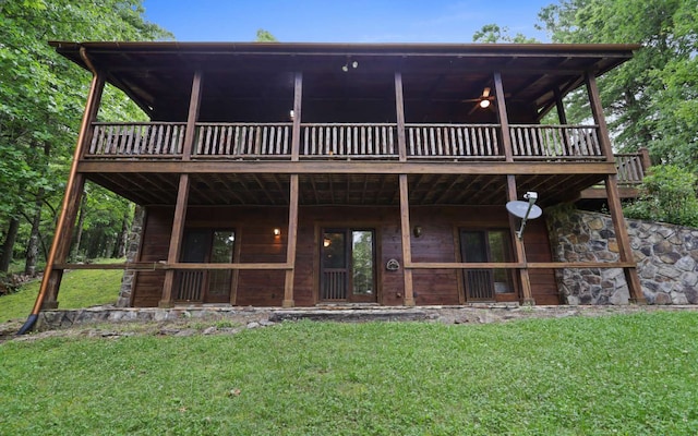 back of property featuring ceiling fan, a yard, and a deck