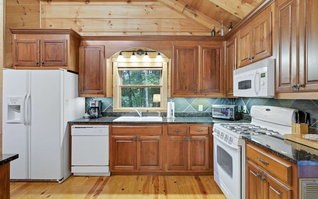 kitchen featuring sink, wood ceiling, lofted ceiling with beams, dark stone countertops, and white appliances