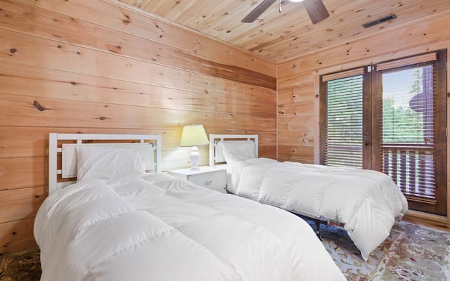 bedroom with ceiling fan, access to exterior, wooden ceiling, and wooden walls