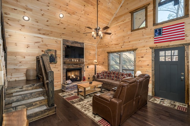 living room featuring dark hardwood / wood-style flooring, high vaulted ceiling, wood walls, a fireplace, and wood ceiling