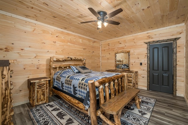 bedroom with dark hardwood / wood-style floors, ceiling fan, and wood walls