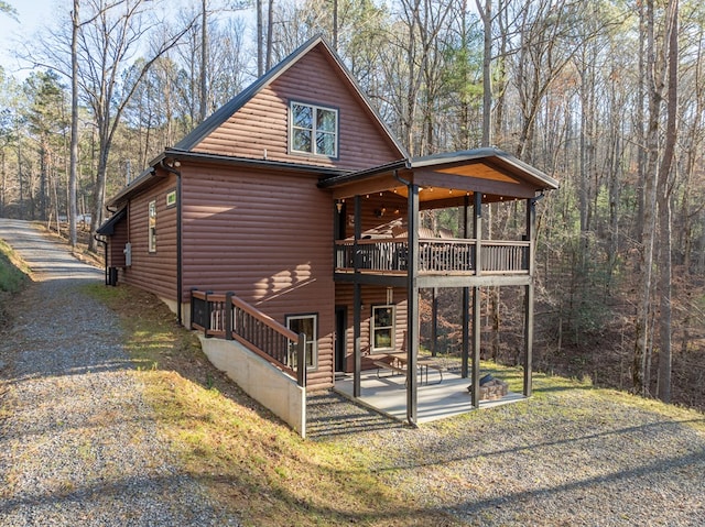 rear view of property featuring a balcony and a patio