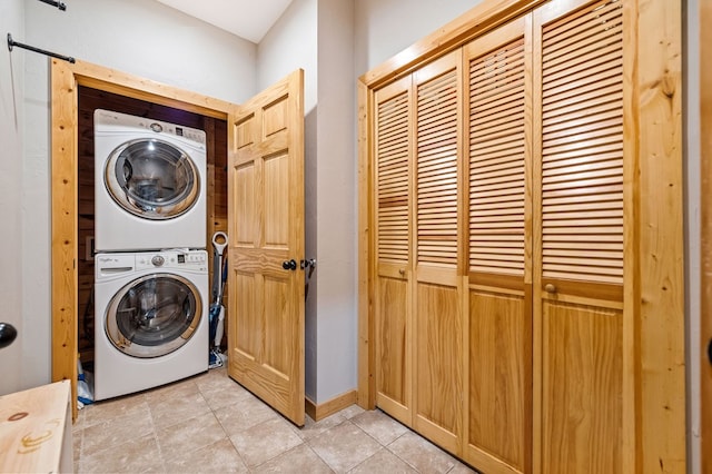 washroom with light tile patterned flooring and stacked washer and clothes dryer