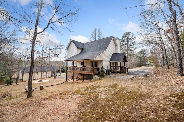 rear view of house featuring a wooden deck