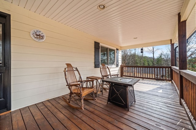 wooden deck featuring an outdoor fire pit