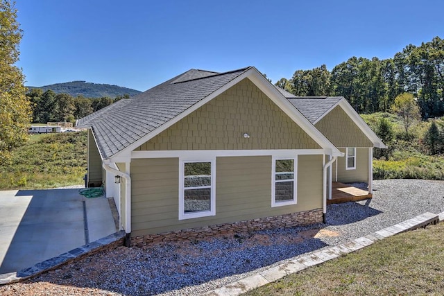 view of side of property featuring a mountain view and a patio