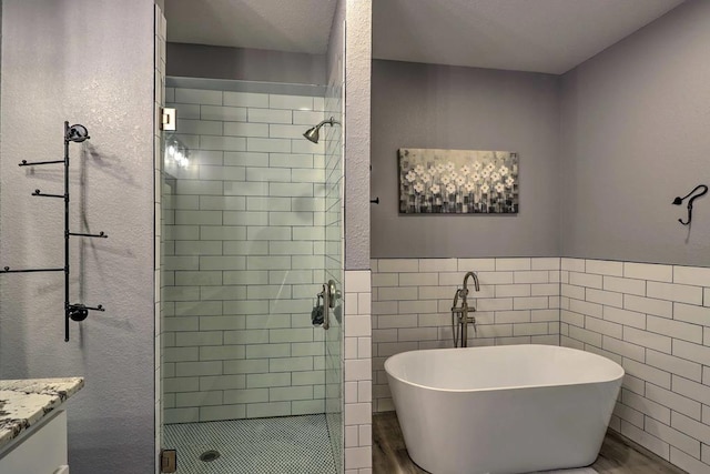 bathroom featuring vanity, wood-type flooring, and shower with separate bathtub