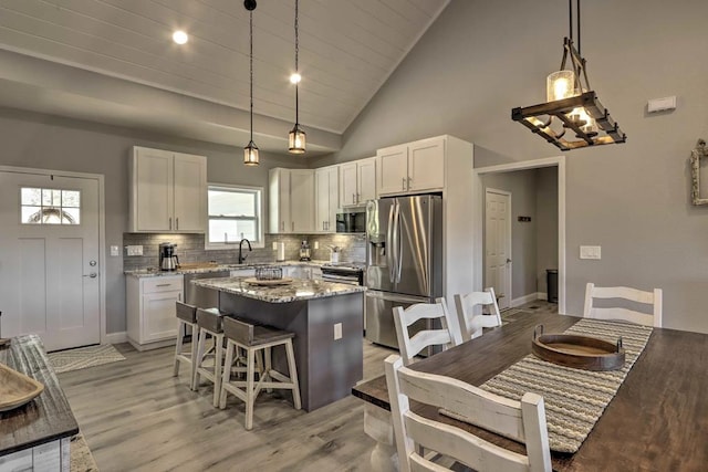 kitchen with a center island, stainless steel appliances, and decorative light fixtures