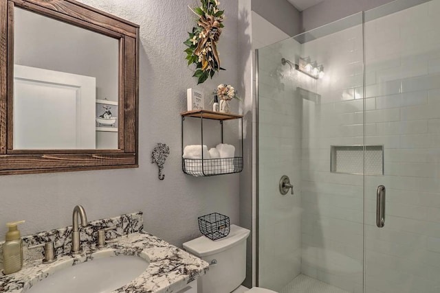 bathroom featuring vanity, toilet, and walk in shower