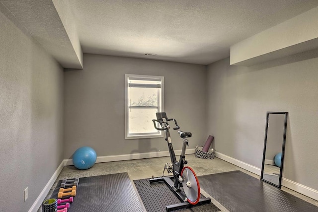 workout room featuring a textured ceiling