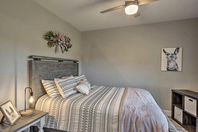bedroom with wood finished floors, a ceiling fan, and baseboards