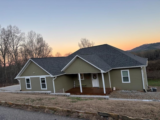 view of front of property featuring a shingled roof, covered porch, and central AC unit